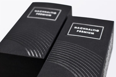 Zwei schwarze, nebeneinander liegende Parfumverpackungen mit Relieflack veredelt