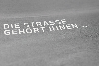 Postkarte mit grauem Hintergrund und dem Text - Die Straße gehört Ihnen...