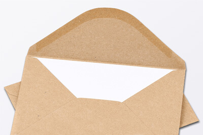 Geöffneter brauner Briefumschlag, bei dem man die Gummierung sieht. In diesem Briefumschlag steckt ein weißes Papier.